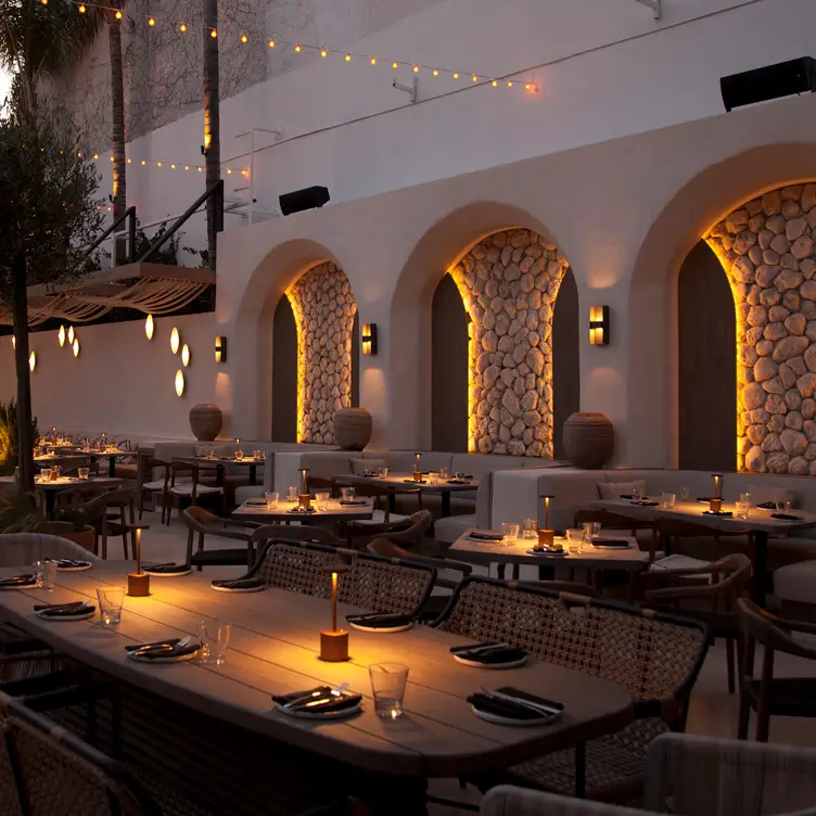 Mediterranean-inspired restaurant patio with arched stone alcoves and ambient lighting