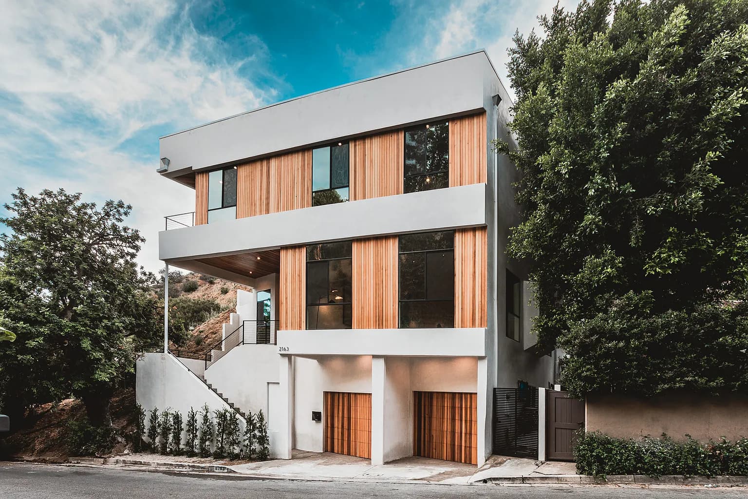 Modern luxury home with wood and white facade in Outpost Estates Hollywood Hills