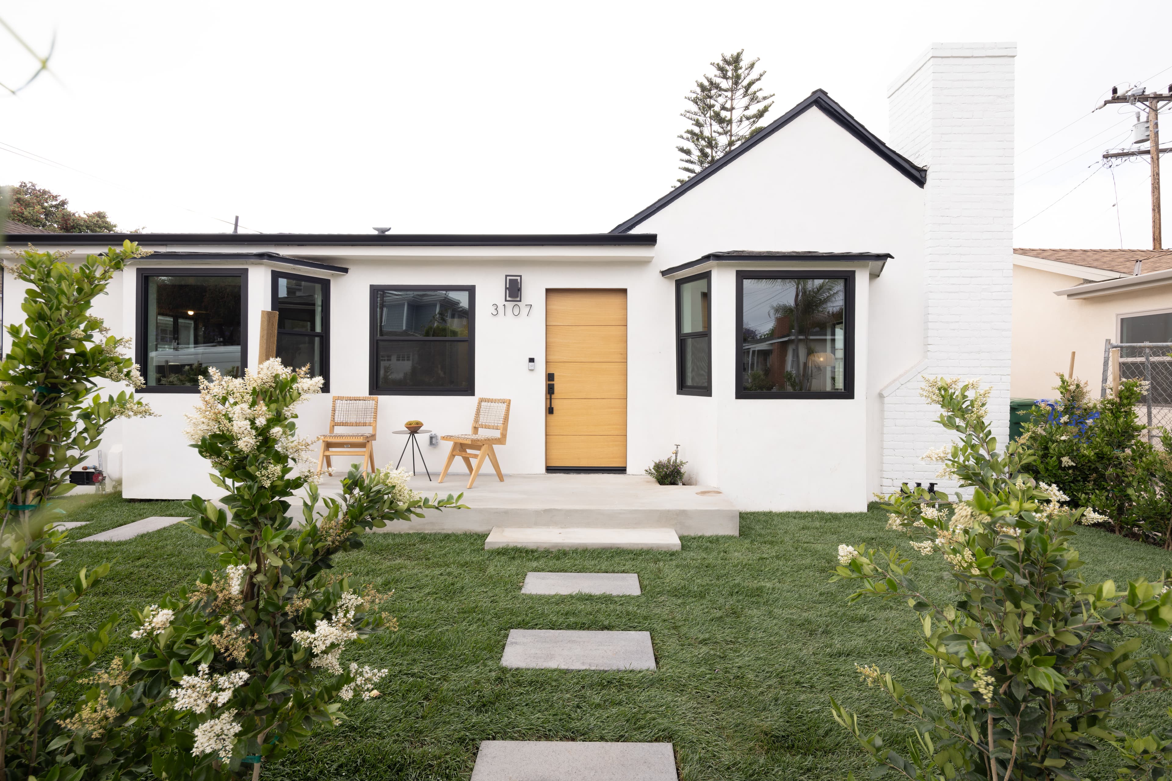 White modern home exterior with gold door and landscaped front yard on Pearl Street Santa Monica